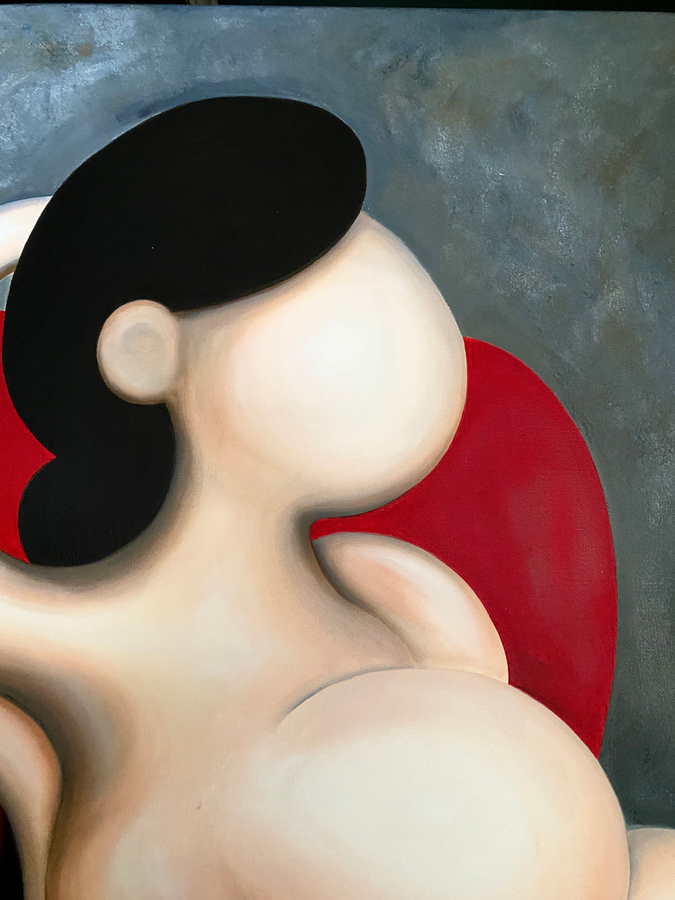 Female reclining on red chair